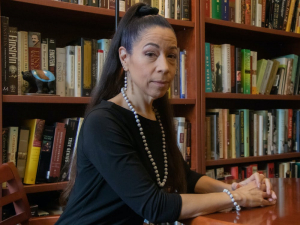 Courtney Lewis in an office in front of bookshelves