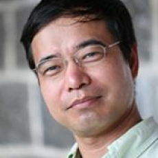 Image of Yongming Zhou with short black hair, glasses, and a light green dress shirt