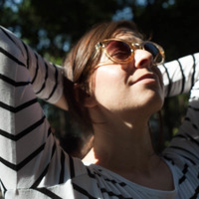 Image of Stephanie Friede in a long-sleeved striped shirt and sunglasses
